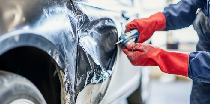 Expert auto body repair specialist restores dented car fenders