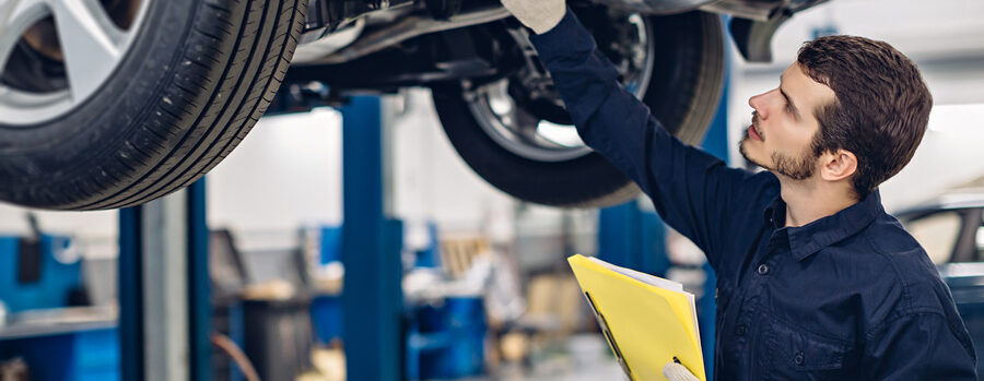 Mechanic examining car in an auto car repair service shop